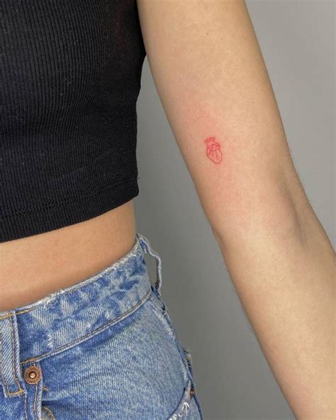 Minimalist anatomical heart tattoo in red ink