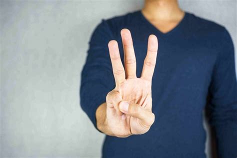 three finger salute hand gesture, on light grey background - Infinity Business Brokers