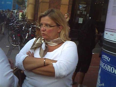 SEXY MATURE LADY WEARING GLASSES STANDING IN A LEATHER SKIRT