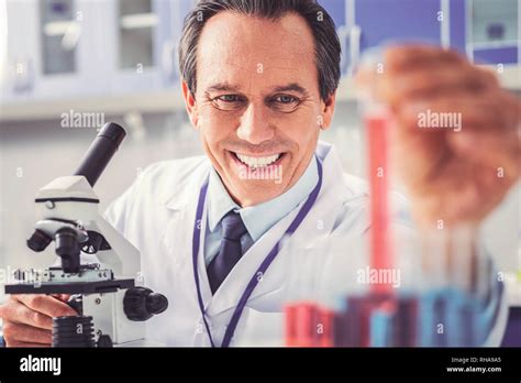 Physician feeling satisfied using new microscope Stock Photo - Alamy