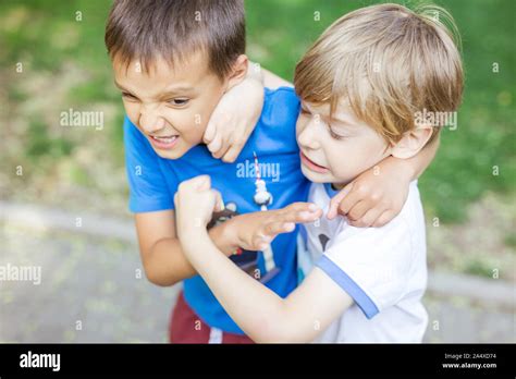 Two boys fighting outdoors. Friends wrestling in summer park. Siblings ...