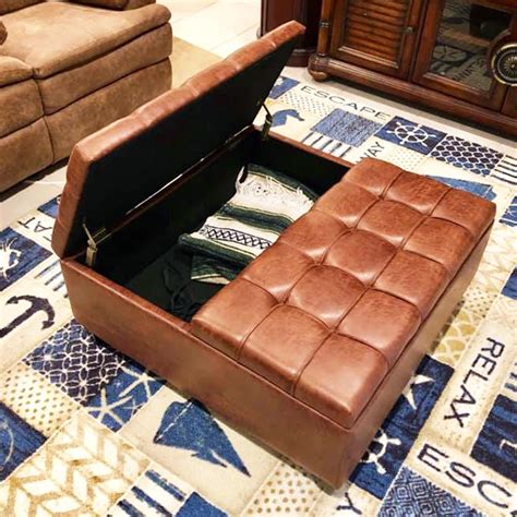 a brown leather ottoman sitting on top of a rug