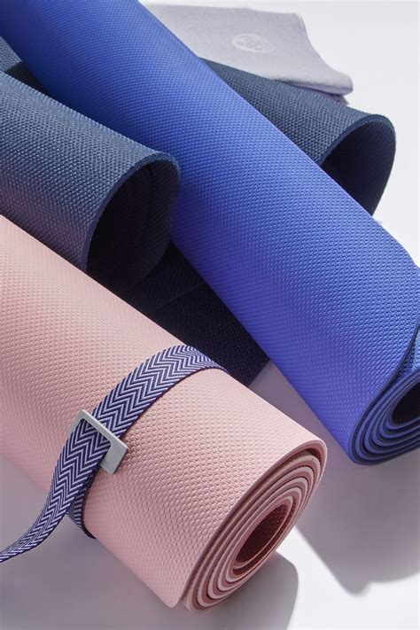 several yoga mats laid out on top of each other, with one rolled up in the middle