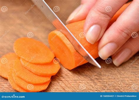 Carrot Cutting. Female Hands with a Knife Chop the Carrots on a Cutting ...