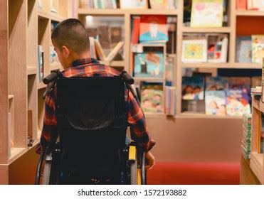 Kid Sitting Wheelchair Library Photos, Images and Pictures