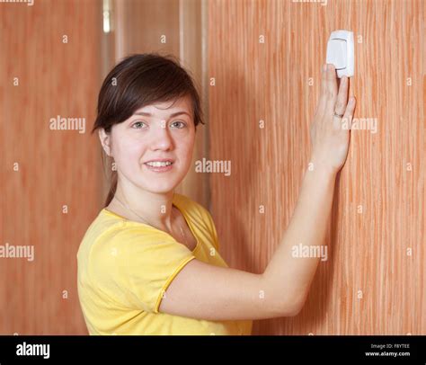 Young woman turning off the light switch in home Stock Photo - Alamy