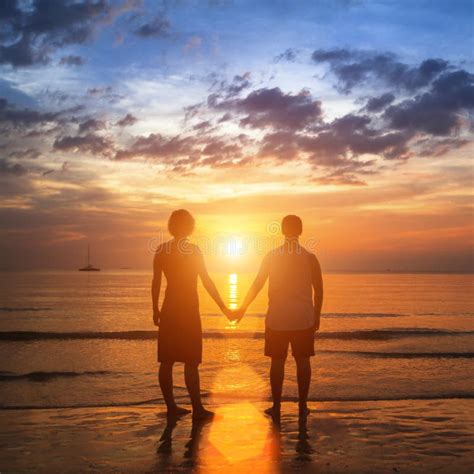 Jeunes Couples Heureux Tenant Des Mains Sur La Plage De Mer Pendant Le Beau Coucher Du Soleil ...