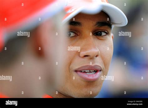 British Formula One driver Lewis Hamilton of McLaren Mercedes (R) talks to his teammate ...