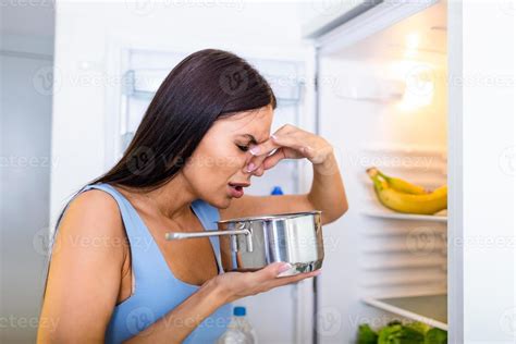 Bad Food In Fridge, young woman in holding her nose because of bad ...