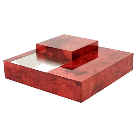 The varnished goatskin parchment, in rich shades of light cherry red, makes this coffee table ...
