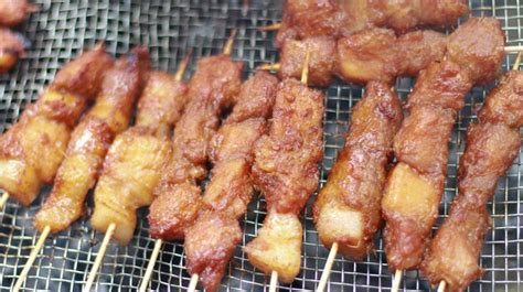 Premium Photo | A grill with skewers of pork skewers on it.