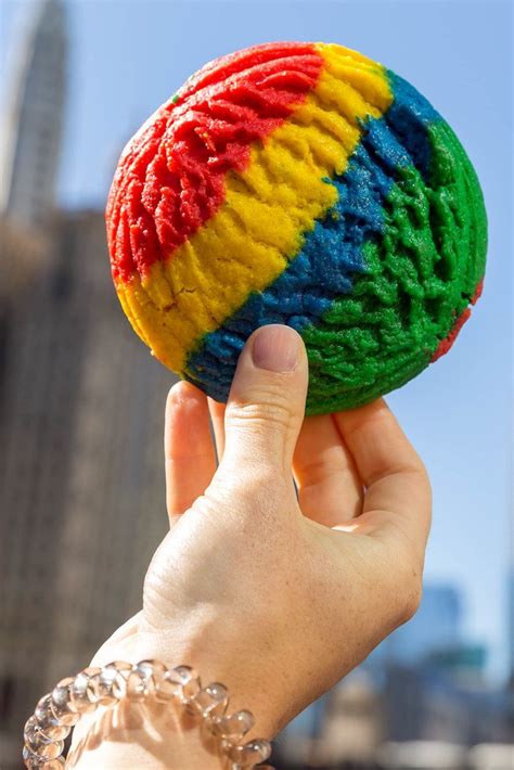 Close-up of a piece of colorful rainbow cookie held between two fingers - Creative Commons Bilder