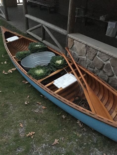 A classic restored wooden canoe holds an aluminum tub ready for ice ...