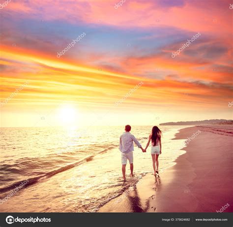 Young Couple Walking Beach Sunset Stock Photo by ©tomwang 375624682