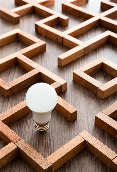 Premium Photo | Light bulb in the maze game built by wood blocks ...