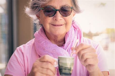 Premium Photo | Portrait of smiling senior caucasian woman in pink and sunglasses holding a ...