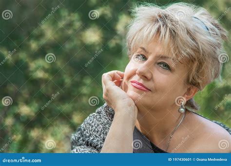 Beautiful Active Caucasian Mature Woman about 62 Years Old is Sitting on the Bench Marked for ...