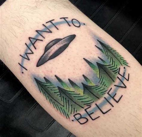 A flying saucer above the forest and words ‘I want to believe’ tattooed in an old-school style ...