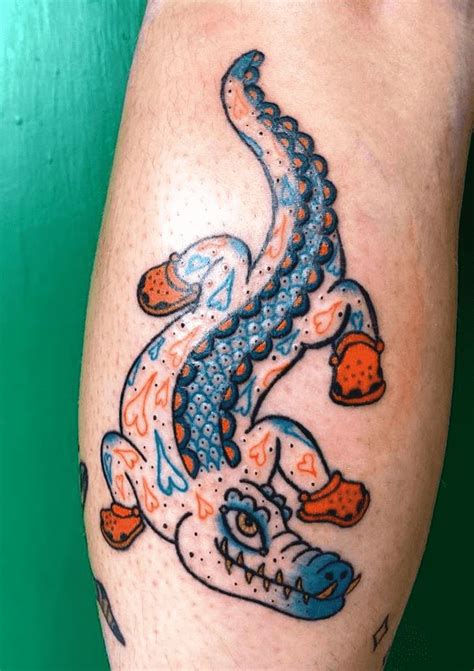 a tattoo on the leg of a person with a dragon design on it's arm