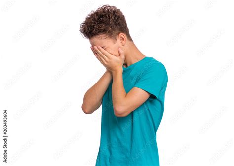 Foto Stock Portrait of teen boy with sad expression covering face with hands while crying ...