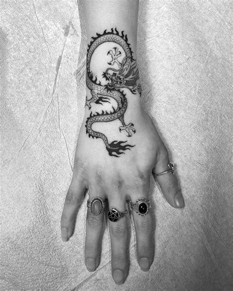 a woman's hand with a dragon tattoo on it