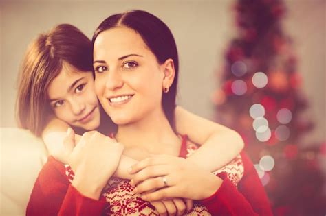 Premium Photo | Festive mother and daughter smiling at camera at home ...
