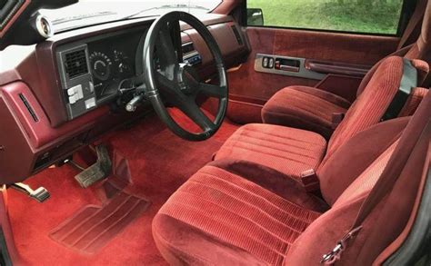 the interior of a car with red velvet seats and steering wheel ...