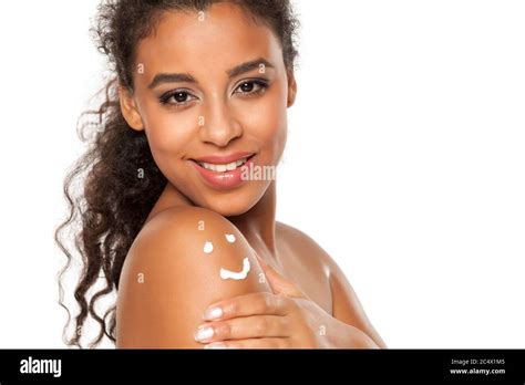 Beautiful dark skinned woman with body lotion on her shoulder on white background Stock Photo ...
