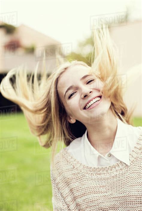 Portrait of happy young girl tossing hair - Stock Photo - Dissolve