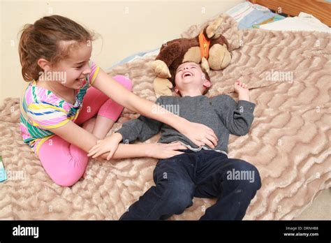 Sister tickling her younger brother Stock Photo: 66242828 - Alamy