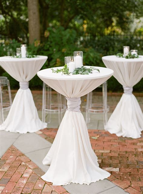 White Pillar Candles and Greenery Atop Cocktail Tables | Wedding cocktail tables, Outdoor ...