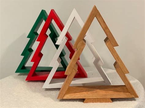 three wooden christmas trees sitting on top of a white table next to eachother
