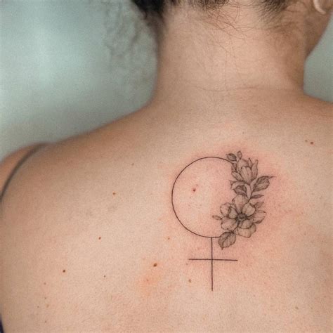 Venus symbol and flowers tattoo located on the upper