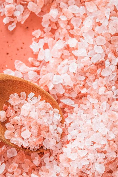 a wooden spoon filled with pink himalayan salt