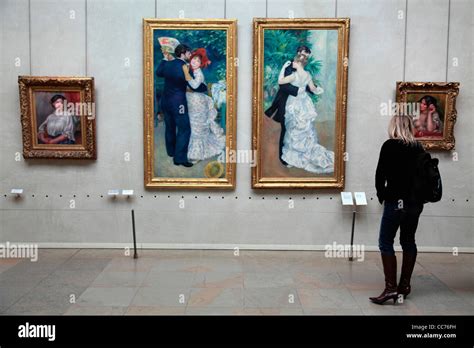 France, Paris, Visitor looking at the works of Pierre Auguste Renoir in ...