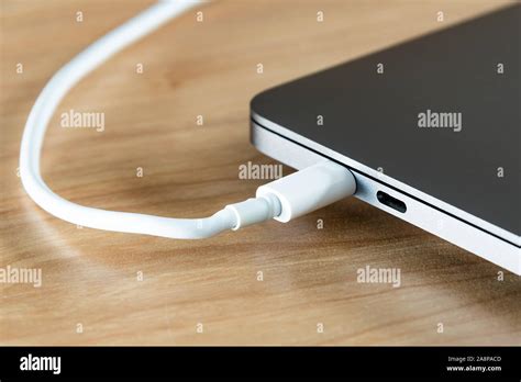 A USB type C cable and USB type C port at a laptop computer Stock Photo ...