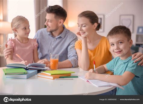 Little children with parents doing homework at home Stock Photo by ©belchonock 249554242