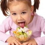 Little girl licks fruit salad Stock Photo by ©Kobyakov 5107476