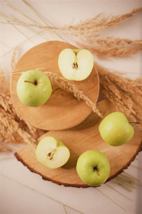 Green apples arranged on wooden boards with wheat spikes · Free Stock Photo