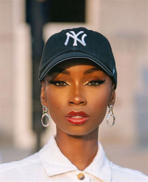 a woman wearing a yankees hat and earrings