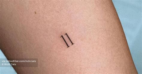 Number "11" tattooed on the inner arm.