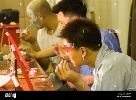 Chinese beijing opera performers applying their makeup before the evening s performance in ...