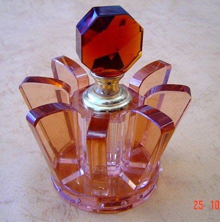 a pink glass perfume bottle sitting on top of a table