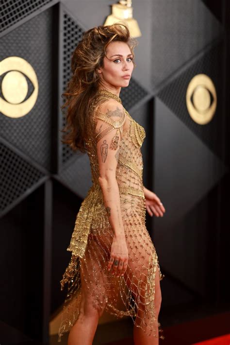 (X) Miley Cyrus dares to ʙᴀʀᴇ on Grammys 2024 red carpet in dress made entirely of safety pins ...