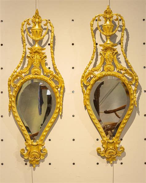 Lot - A pair of ornately carved giltwood wall mirrors. 39 x 14 in. (99 x 36 cm)