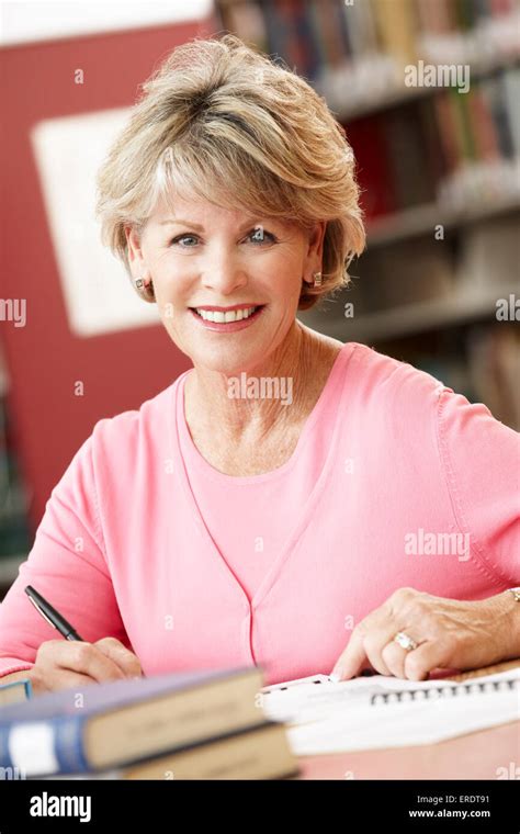 Mature student working in library Stock Photo - Alamy