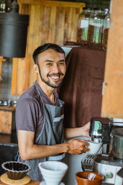 Premium Photo | Asian male barista in apron standing with smile while ...