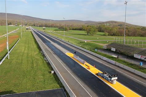 an aerial view of a highway with cars driving on the road and green fields in the background