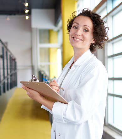 Portrait Of A Female Doctor Holding Her Patient Chart In Stock Photo - Download Image Now - iStock