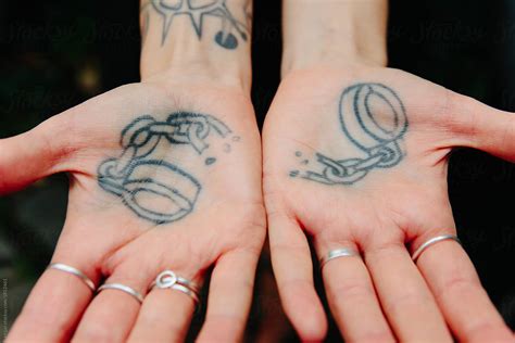 "A Tattoo Of Broken Handcuffs On The Palms Of Two Hands" by Stocksy Contributor "Kkgas" - Stocksy